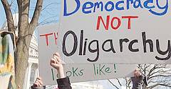 Protestierende mt einem Plakat "Democracy not Oligarchy."