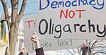 Protestierende mt einem Plakat "Democracy not Oligarchy."