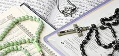 Die heiligen Schriften des Judentums, Islams und Christentums mit den entsprechenden religiösen Symobolen.