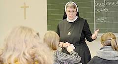 Eine Ordensfrau unterrichtet in der Schule.